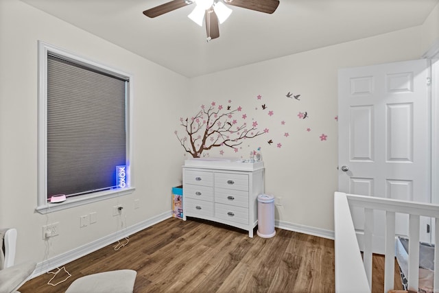 bedroom with ceiling fan, baseboards, and wood finished floors