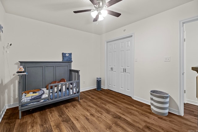 bedroom with a ceiling fan, a closet, baseboards, and dark wood-type flooring