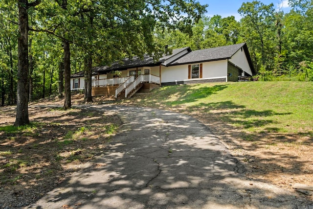 view of front of home with aphalt driveway and a front yard