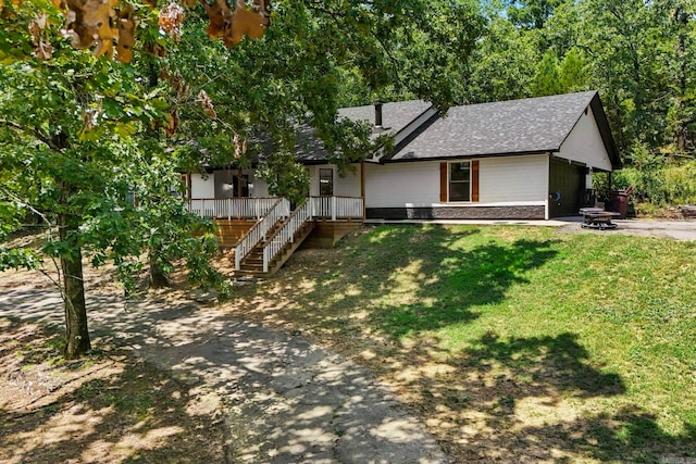 view of front of property featuring a front yard, roof with shingles, an outdoor fire pit, and stairway