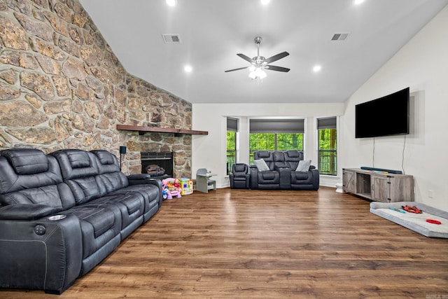 living room with high vaulted ceiling, visible vents, wood finished floors, and a stone fireplace