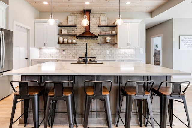 kitchen with white cabinetry, open shelves, and freestanding refrigerator