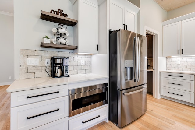 kitchen with open shelves, appliances with stainless steel finishes, light wood-style flooring, and white cabinetry