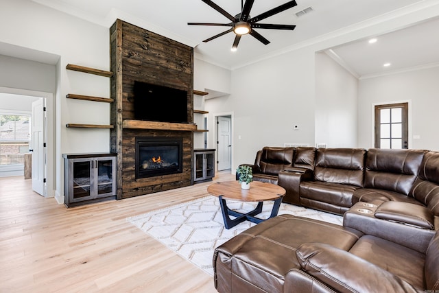 living area with light wood-type flooring, visible vents, plenty of natural light, and a fireplace