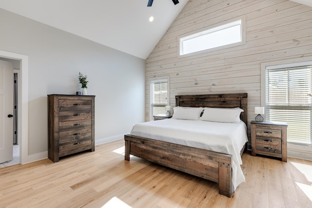 bedroom with light wood-type flooring, ceiling fan, multiple windows, and high vaulted ceiling