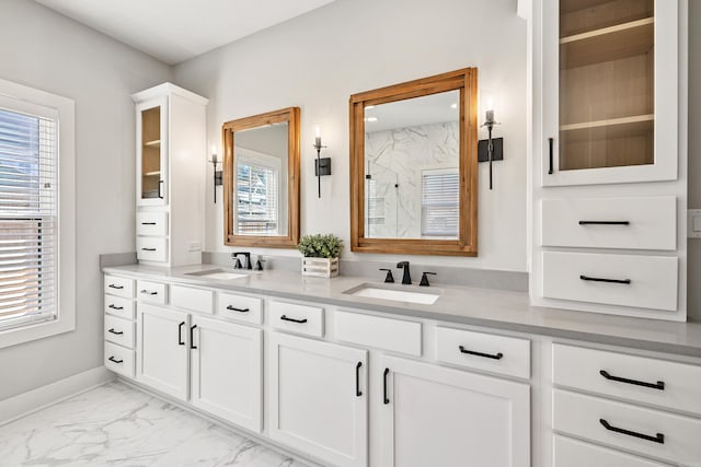 full bathroom featuring marble finish floor, double vanity, a sink, and a marble finish shower