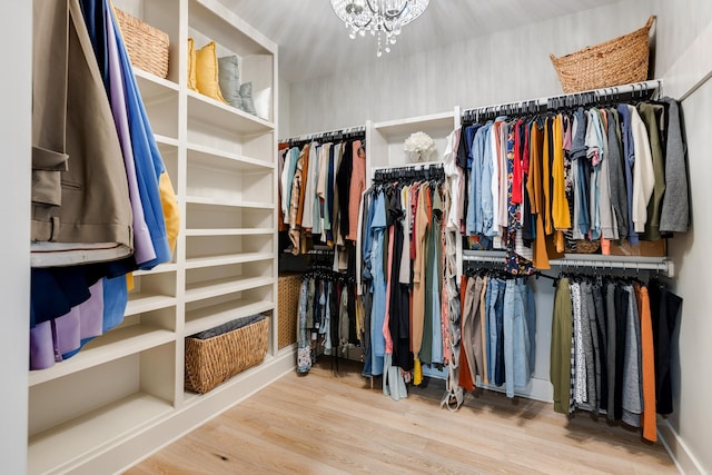 spacious closet featuring a chandelier and wood finished floors