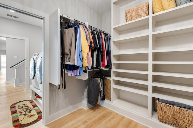 walk in closet featuring visible vents, independent washer and dryer, and wood finished floors