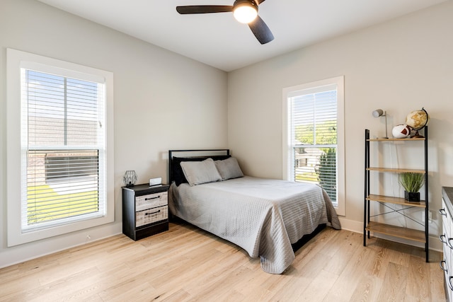 bedroom with light wood-style flooring, baseboards, and ceiling fan