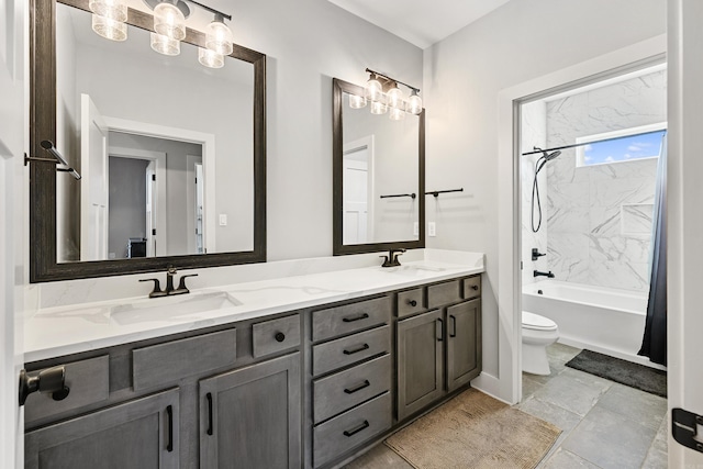 bathroom with double vanity, bathing tub / shower combination, a sink, and toilet