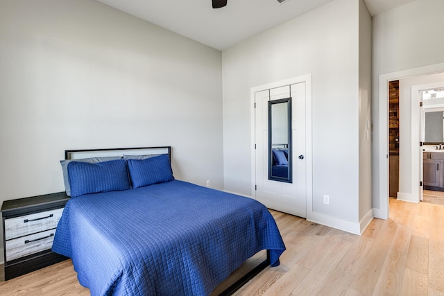 bedroom featuring a ceiling fan, light wood-style flooring, and baseboards