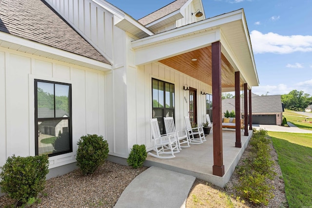 doorway to property with covered porch, a shingled roof, and board and batten siding