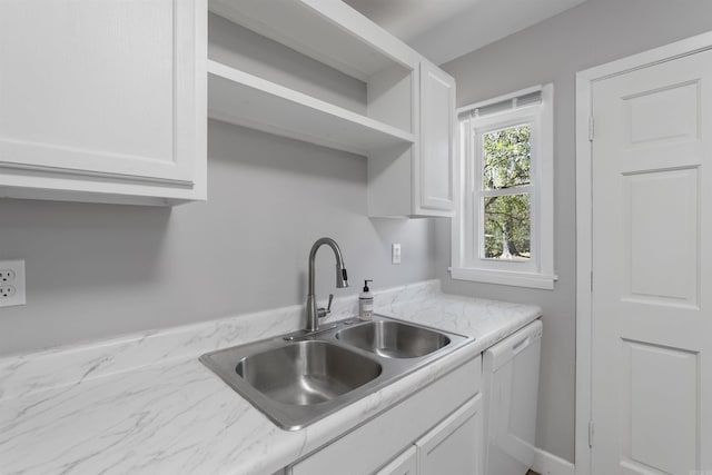 kitchen featuring white dishwasher, a sink, and white cabinets