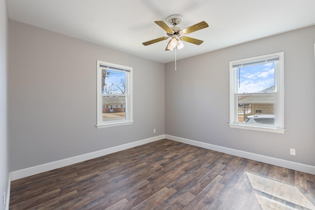 unfurnished room with a ceiling fan, dark wood finished floors, and baseboards