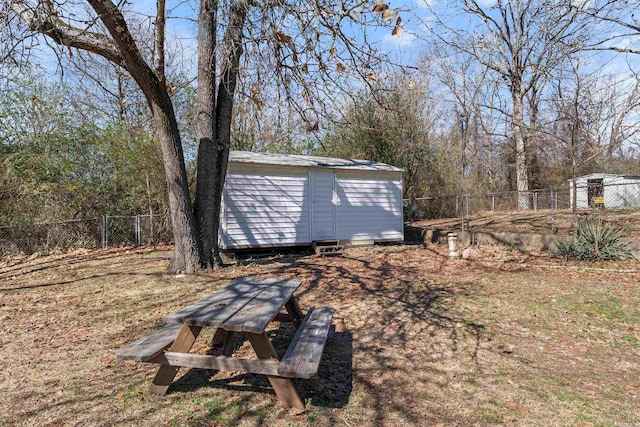 view of yard with a fenced backyard, an outdoor structure, and a shed