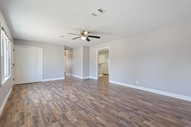 spare room featuring baseboards, visible vents, and dark wood-style flooring