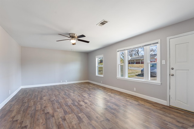 unfurnished room with baseboards, visible vents, ceiling fan, and wood finished floors