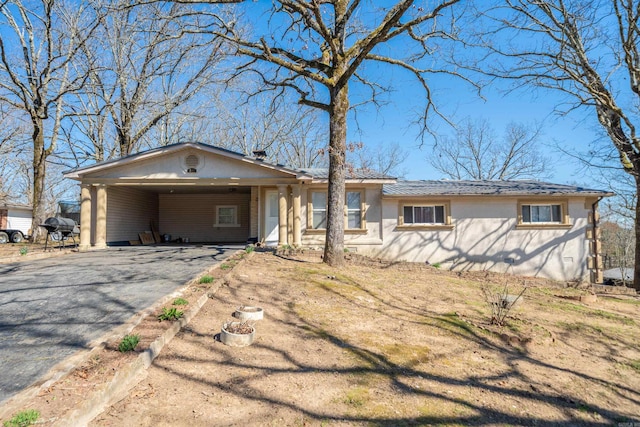 single story home featuring driveway and a carport