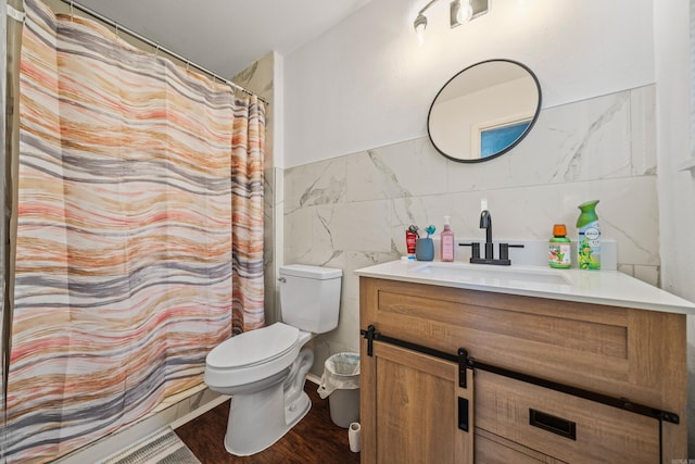 bathroom featuring wood finished floors, vanity, toilet, and tile walls