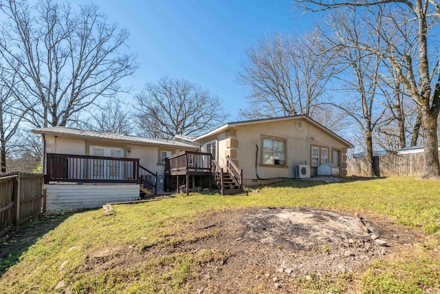 rear view of property featuring a fenced backyard, metal roof, a lawn, and a wooden deck