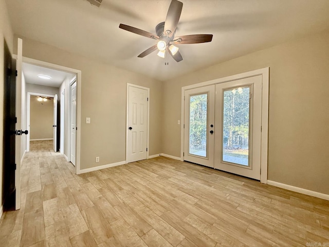 interior space featuring light wood finished floors, baseboards, and french doors