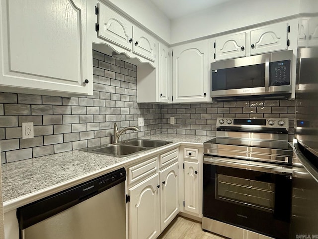 kitchen featuring appliances with stainless steel finishes, decorative backsplash, a sink, and light countertops