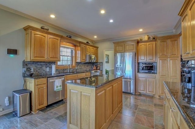 kitchen featuring decorative backsplash, dark stone counters, appliances with stainless steel finishes, a center island, and a sink