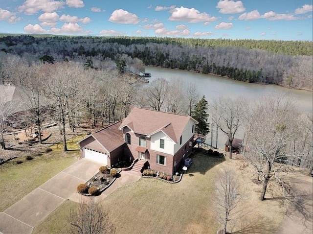 birds eye view of property with a water view and a wooded view