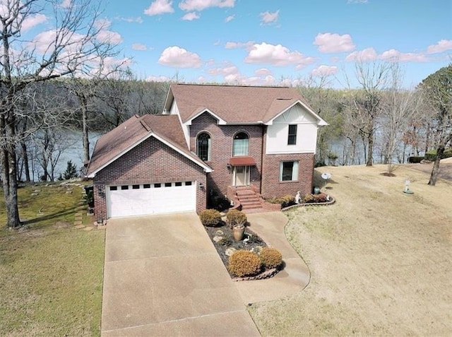 traditional home with an attached garage, a front yard, concrete driveway, and brick siding