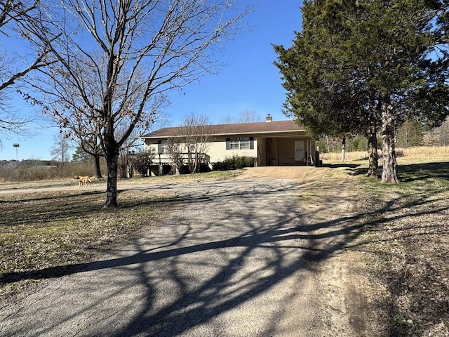 view of front of house featuring driveway and a chimney