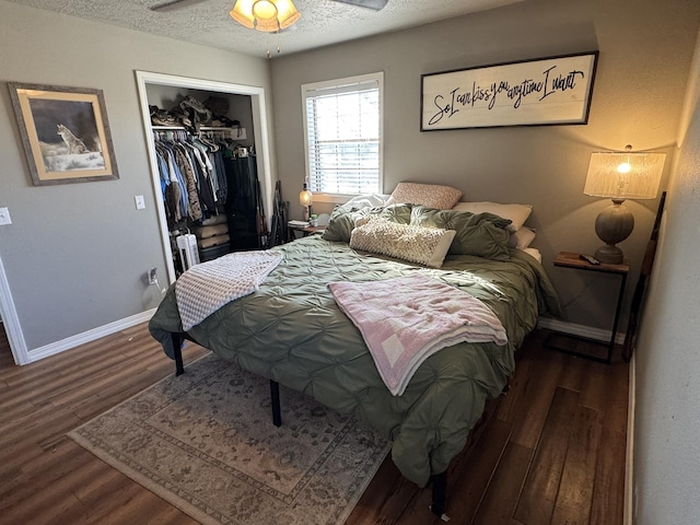 bedroom featuring a closet, a textured ceiling, baseboards, and wood finished floors