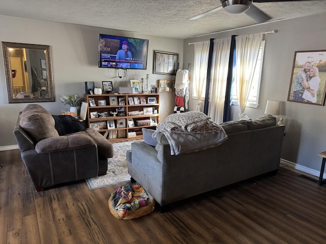 living room featuring ceiling fan, a textured ceiling, baseboards, and wood finished floors