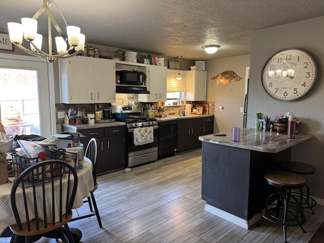 kitchen with decorative backsplash, white cabinetry, a sink, dark cabinets, and black appliances