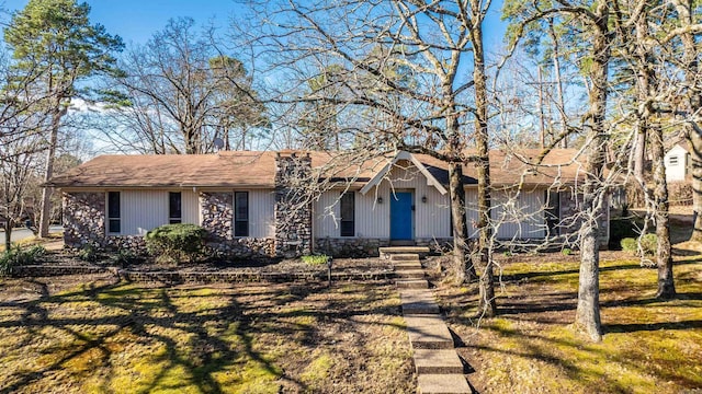 ranch-style house with stone siding and a front yard