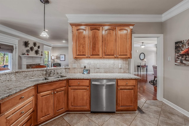 kitchen featuring backsplash, light stone countertops, crown molding, stainless steel dishwasher, and a sink