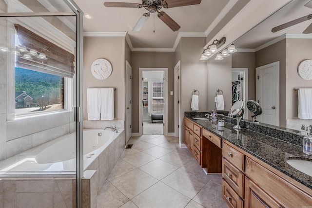 bathroom with double vanity, ornamental molding, a sink, tile patterned flooring, and a bath