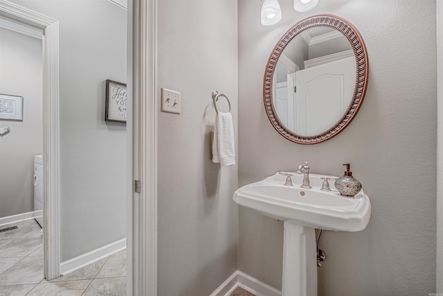 half bathroom with visible vents, baseboards, and tile patterned floors