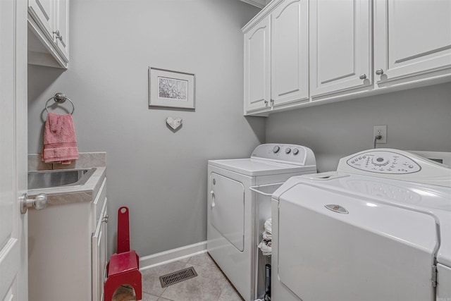 laundry room featuring cabinet space, light tile patterned floors, baseboards, visible vents, and washer and clothes dryer