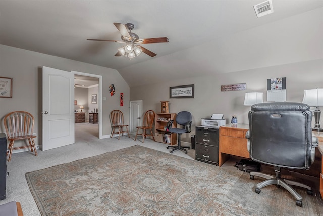 carpeted office space featuring baseboards, visible vents, vaulted ceiling, and a ceiling fan