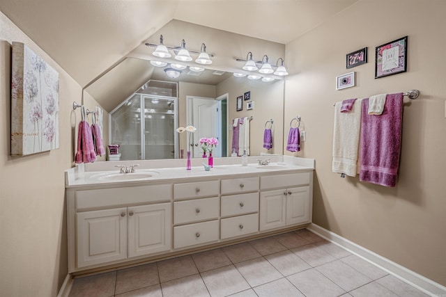 bathroom with double vanity, a sink, a shower stall, baseboards, and tile patterned floors