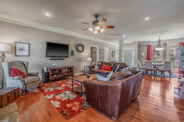 living area featuring crown molding, decorative columns, hardwood / wood-style floors, and a ceiling fan