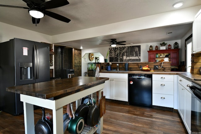 kitchen with white cabinetry, dark wood finished floors, a peninsula, and black appliances