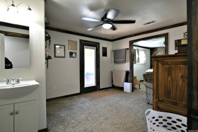 bathroom with ornamental molding, a wealth of natural light, visible vents, and a textured ceiling