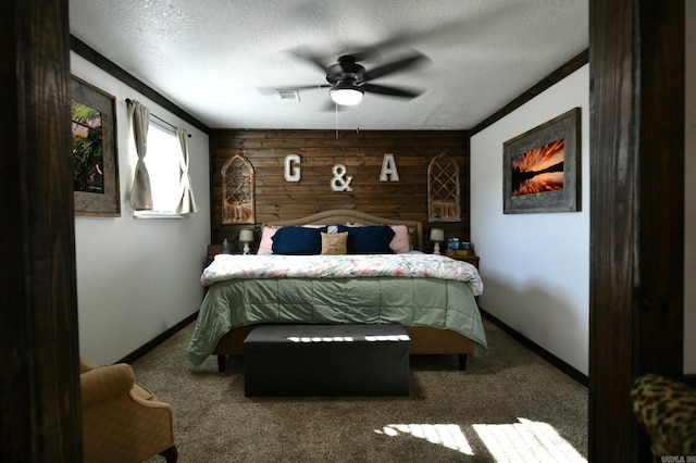 carpeted bedroom featuring a textured ceiling, baseboards, visible vents, and wooden walls