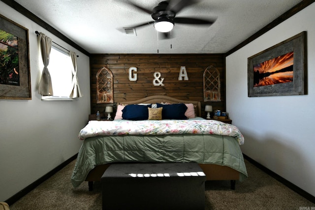 bedroom with visible vents, baseboards, carpet, a textured ceiling, and wood walls