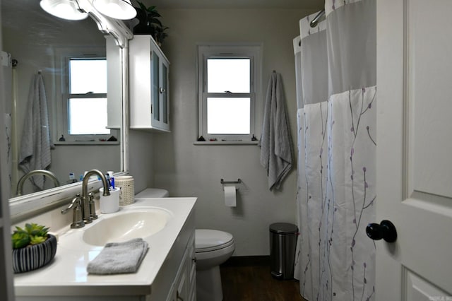 bathroom featuring curtained shower, toilet, wood finished floors, vanity, and baseboards