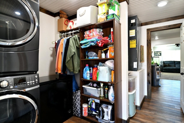 clothes washing area with wood finished floors and stacked washer / drying machine