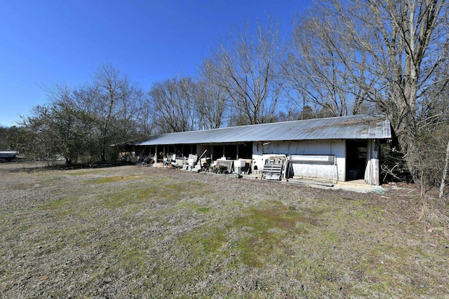 exterior space with an outbuilding, a pole building, and metal roof