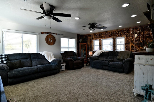 living room with a wealth of natural light, carpet, and a textured ceiling