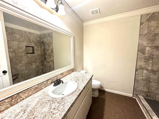 bathroom featuring visible vents, tiled shower, toilet, ornamental molding, and vanity